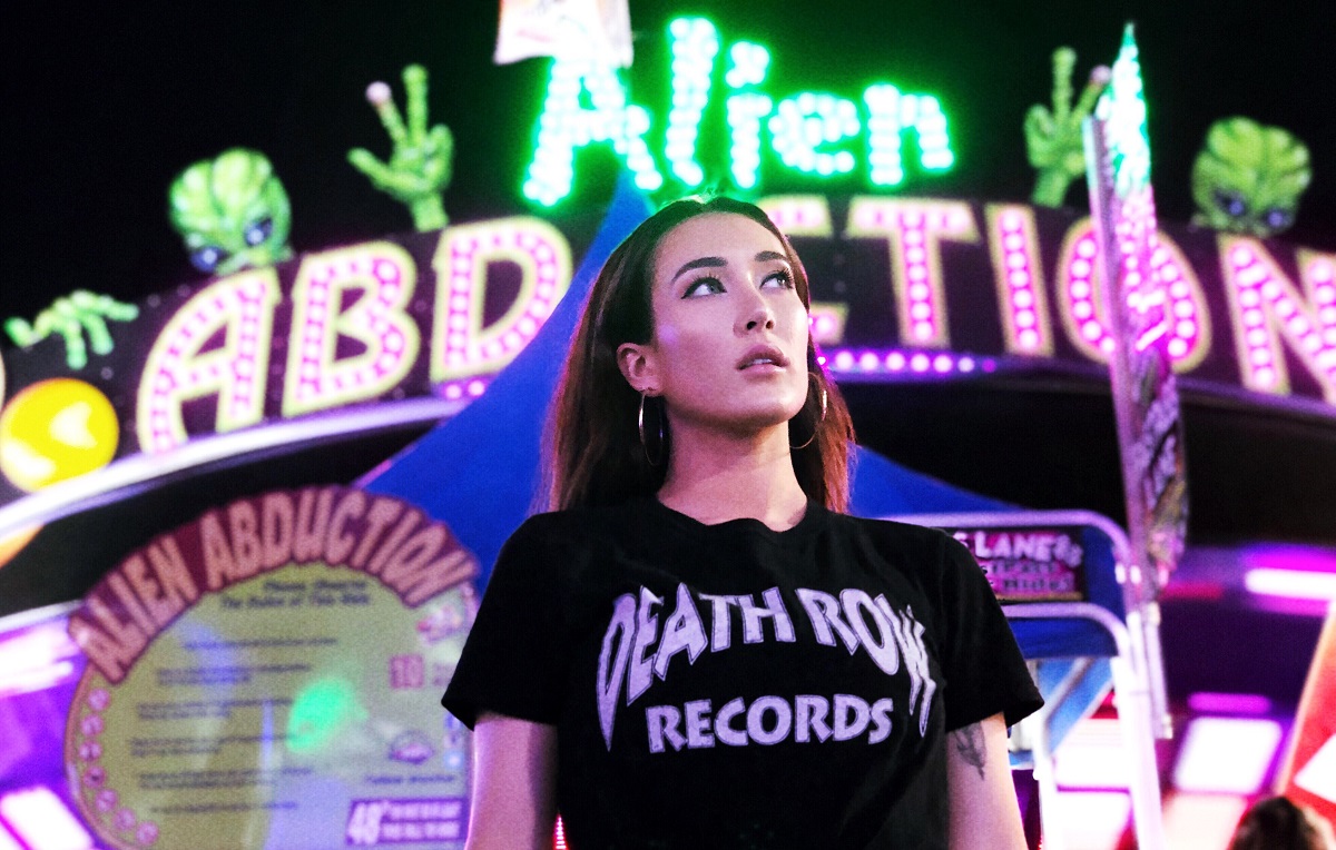 Aubrie Sellers in front of psychedelic neon carnival lights