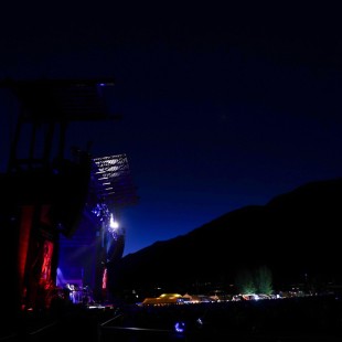 Sam Bush Band backgrounded by the mountains and evening sky.