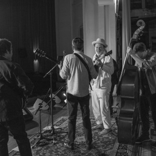 John C Reilly takes the stage with the evening's house band and Ed Helms. By Josh Wool.