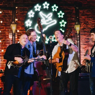 Our A Bluegrass Situation co-hosts and house band, Ed Helms and Noam Pikelny with Jacob Tilove and Ian Riggs of the Lonesome Trio. By Nina Westervelt.