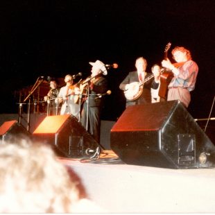 Earl Scruggs and Doc Watson perform at the first MerleFest in 1988, then called the "Merle Watson Memorial Festival." (L to R:) Marty Stuart, Jim Shumate, Mac Wiseman, Earl Scruggs, unknown bassist, Jack Lawrence, Doc Watson.